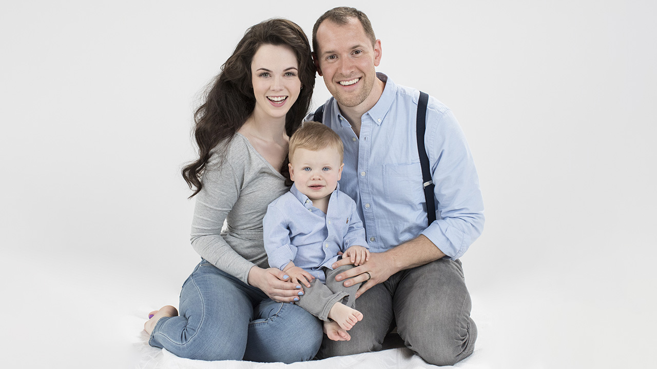 Look the baby work. Baby look to parents. Parents with Baby background White. Baby with Toddy.