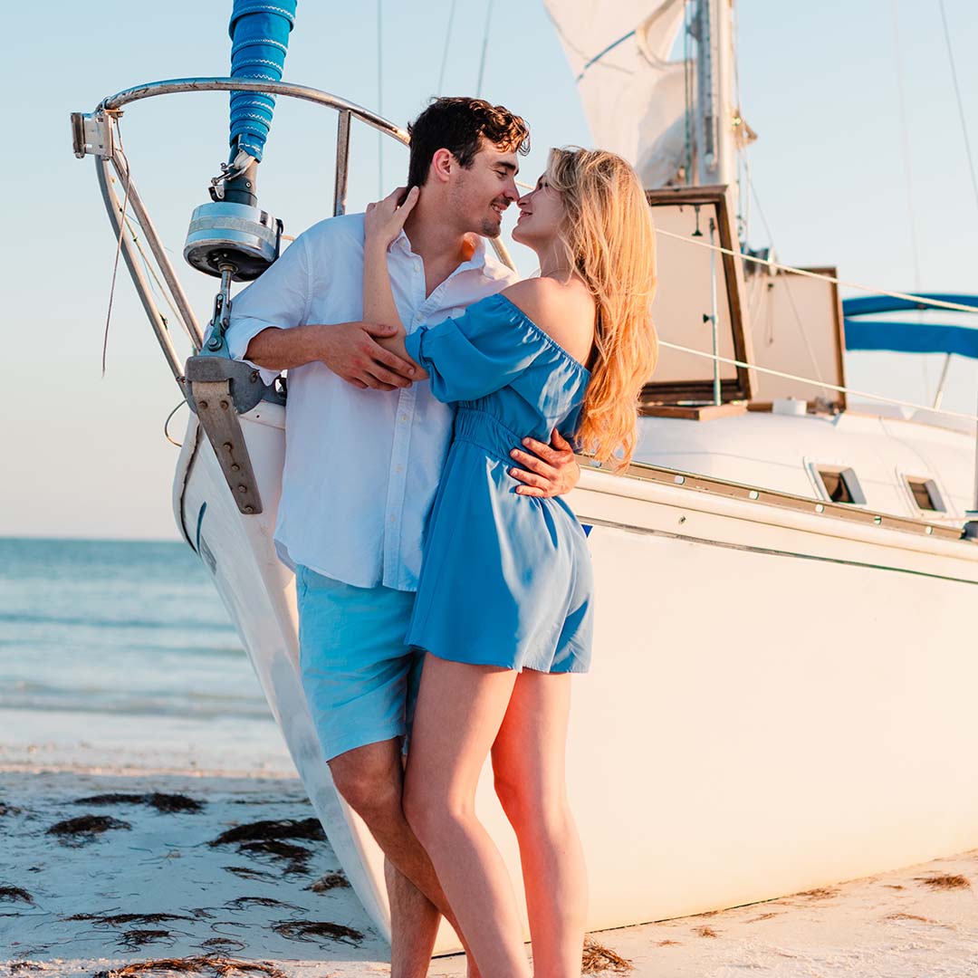 Portrait of a couple in front of a sailboat by Kristina Wikle