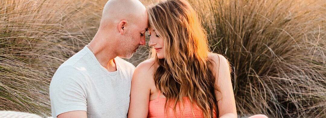Portrait of a couple on the beach by Kristina Wikle